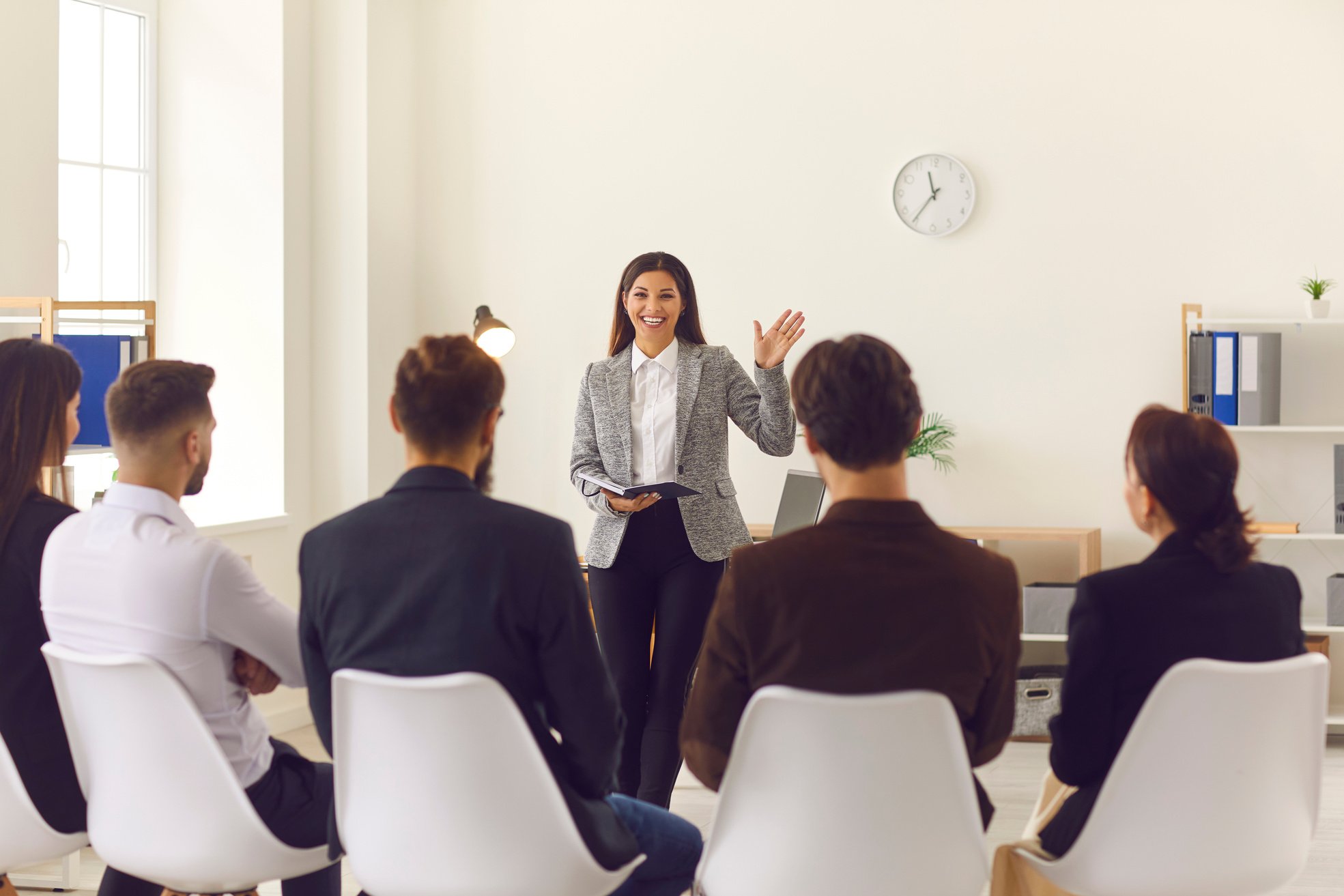 Smiling Company Manager or Team Leader Greeting Workers or Interns in Corporate Meeting